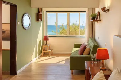 a living room with a green couch and a window at Seaview Ensuite rooms in Sagres centre - Casa Maluka in Sagres