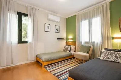 a room with two beds and a chair and a window at Villa Monte in Funchal