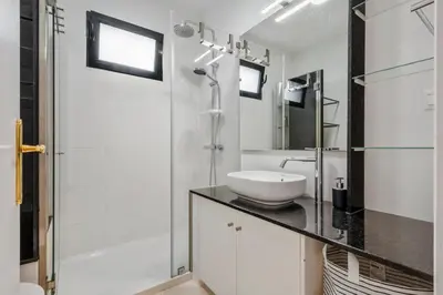 a white bathroom with a sink and a shower at Villa Monte in Funchal