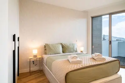 a bedroom with a large bed with towels on it at A peaceful retreat near the city centre in Funchal
