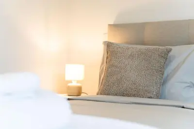 a bedroom with a bed with a pillow and a lamp at A peaceful retreat near the city centre in Funchal