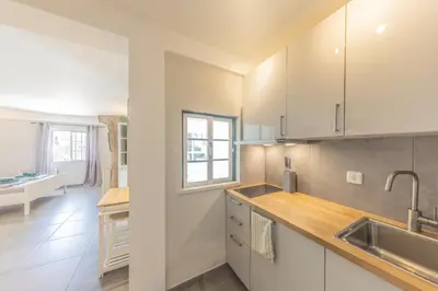 a kitchen with white cabinets and a sink at Living Lodge Portugal in Aljezur