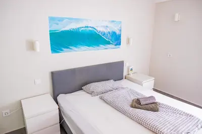 a bedroom with a bed and a painting on the wall at Living Lodge Portugal in Aljezur