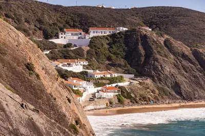 a group of houses on a hill next to a beach at Living Lodge Portugal in Aljezur