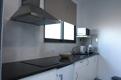 a kitchen with a black counter top and a window at Leais ao Pico in Porto da Cruz
