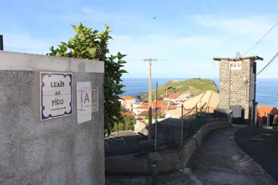 a dining room with a table and a tv at Leais ao Pico in Porto da Cruz
