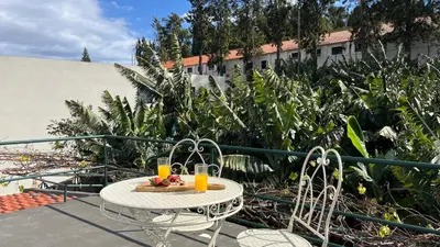 a table with two glasses of orange juice on a balcony at Rosalita s View in Funchal