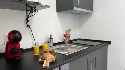 a kitchen counter with a sink and some food and orange juice at Rosalita s View in Funchal