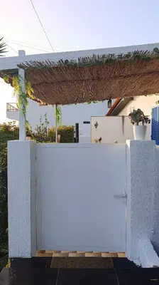 a white fence in front of a house at Kanela Guest House B-side in Machico