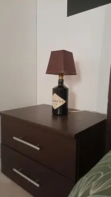 a lamp sitting on a dresser next to a bed at Kanela Guest House B-side in Machico