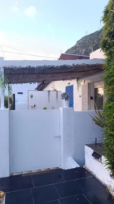a white fence in front of a white house at Kanela Guest House B-side in Machico