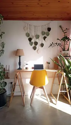 a yellow chair next to a desk with plants at Kanela Guest House B-side in Machico