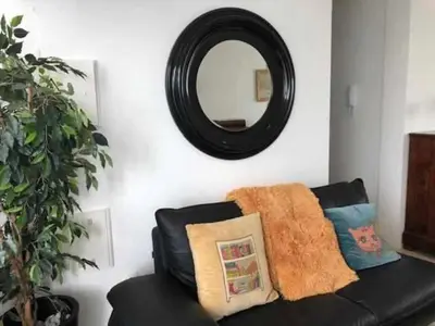 a black couch in a living room with a mirror at GuestReady - Vila Rosa - Renovated Seaviews House in Funchal