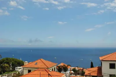 a view of the ocean from the roofs of houses at GuestReady - Vila Rosa - Renovated Seaviews House in Funchal