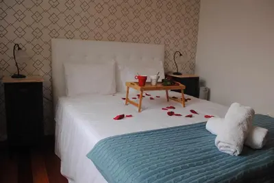 a bedroom with a bed with a table with roses on it at GuestReady - Vila Rosa - Renovated Seaviews House in Funchal