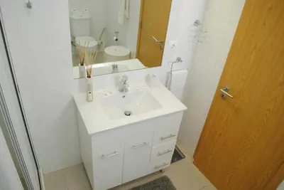 a white bathroom with a sink and a mirror at GuestReady - Vila Rosa - Renovated Seaviews House in Funchal