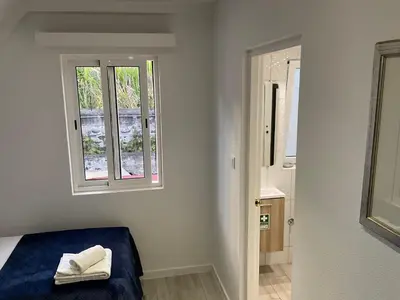 a room with a bed and a window and a bathroom at Sol & Mar Casa Branca in Funchal
