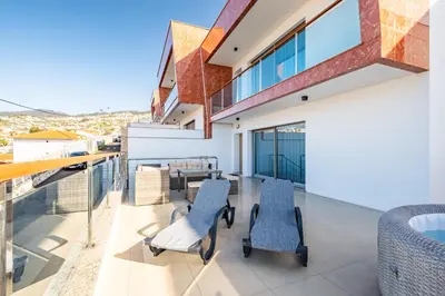 a balcony with chairs and a table on a building at Suburban Views by Homie in Funchal