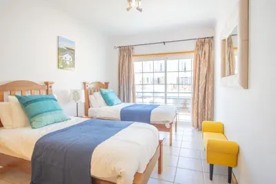 two beds in a room with a window at Baleias Guesthouse - 3 Bedroom Townhouse with private pool & sea view in Luz