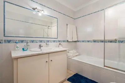 a bathroom with a sink and a tub and a shower at Baleias Guesthouse - 3 Bedroom Townhouse with private pool & sea view in Luz