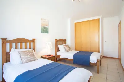 a bedroom with two beds and a lamp in it at Baleias Guesthouse - 3 Bedroom Townhouse with private pool & sea view in Luz