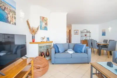 a living room with a blue couch and a table at Baleias Guesthouse - 3 Bedroom Townhouse with private pool & sea view in Luz