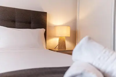 a bedroom with a bed and a lamp on a table at GuestReady - Relax and Recharge in Funchal in Funchal