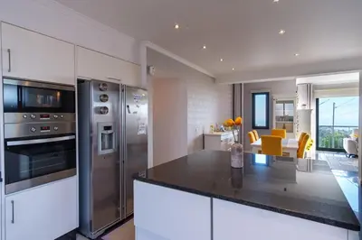 a kitchen with white cabinets and a black counter top at GuestReady - Private Terrace Stay in Funchal
