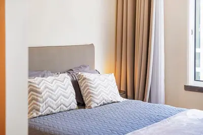 a bed with two pillows sitting next to a window at SUPER Atalaia in Caniço