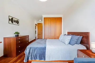 a bedroom with a bed and a wooden dresser at SUPER Atalaia in Caniço