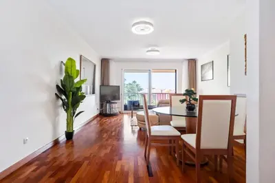 a living room with a table and a dining room at SUPER Atalaia in Caniço
