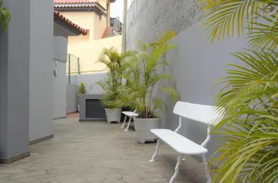 a patio with white chairs and potted plants at Apartamentos Turísticos Vitoria by Petit Hotels in Funchal