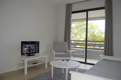 a living room with a couch and a tv and a table at Apartamentos Turísticos Vitoria by Petit Hotels in Funchal