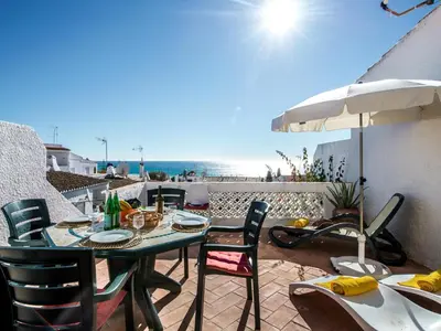 a patio with a table and chairs and an umbrella at Villa Bort Oss in Luz