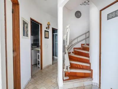 a hallway with stairs in a home with white walls at Villa Bort Oss in Luz