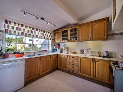 a large kitchen with wooden cabinets and a window at Villa Bort Oss in Luz