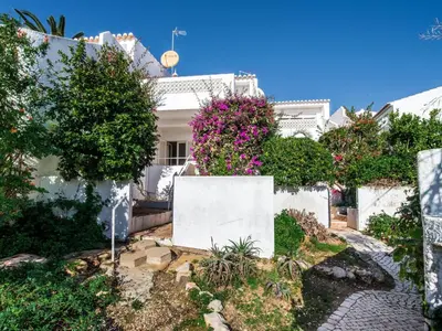 a white house with flowers on the side of it at Villa Bort Oss in Luz