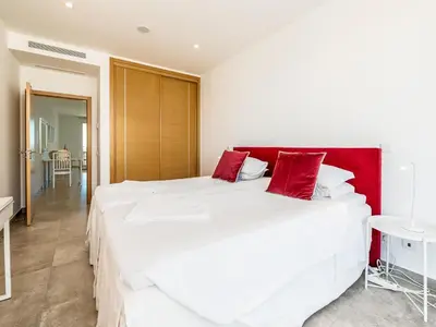 a bedroom with two large white beds with red pillows at Apt. Seabreeze in Lagos