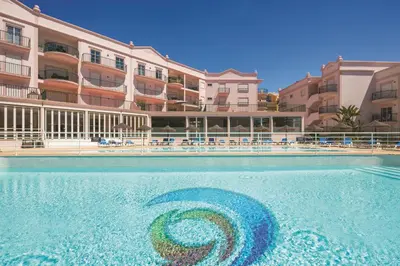 a swimming pool in front of a hotel at Apt. Palmeira in Luz