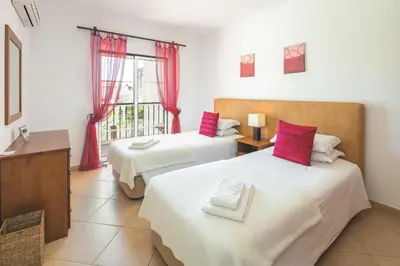 two beds in a room with a window at Apt. Palmeira in Luz