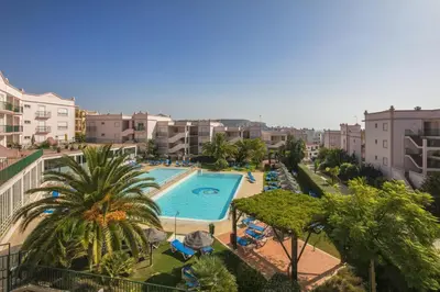 a view of a swimming pool with palm trees and buildings at Apt. Palmeira in Luz
