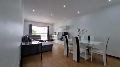 a living room with a table and a dining room at Lexus Apartment - Garajau in Caniço