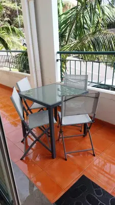 a glass table and two chairs on a balcony at Lexus Apartment - Garajau in Caniço