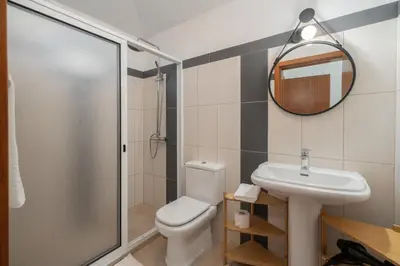 a bathroom with a toilet and a sink and a mirror at Villa Island Roots by An Island Apart in Calheta