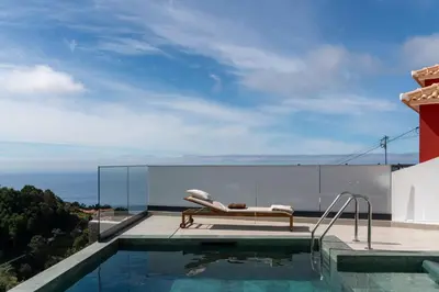 a swimming pool with a lounge chair on the roof of a house at Villa Island Roots by An Island Apart in Calheta