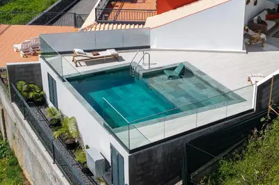 a swimming pool on the side of a house at Villa Island Roots by An Island Apart in Calheta