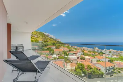 a balcony with a chair and a view of the ocean at Luxury Laura Apartment by Holiday Rental Madeira in Funchal