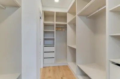 a walk in closet with white walls and white shelves at Luxury Laura Apartment by Holiday Rental Madeira in Funchal