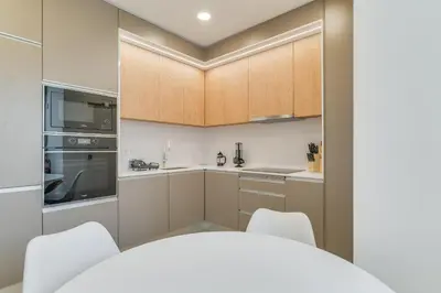 a kitchen with wooden cabinets and white appliances at Luxury Laura Apartment by Holiday Rental Madeira in Funchal