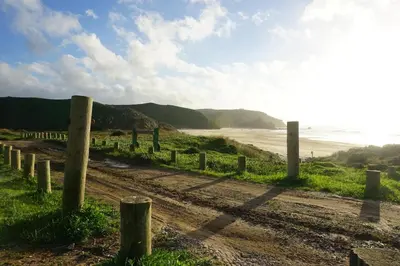 a dirt road next to a beach with a fence at Casa 3 in Raposeira